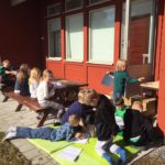 Barn läser och ritar uthomhus