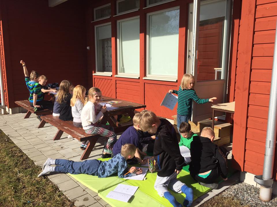 Barn läser och ritar uthomhus