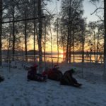 Barn som åker pulka med sjön Yngen i bakgrunden och solnedgång